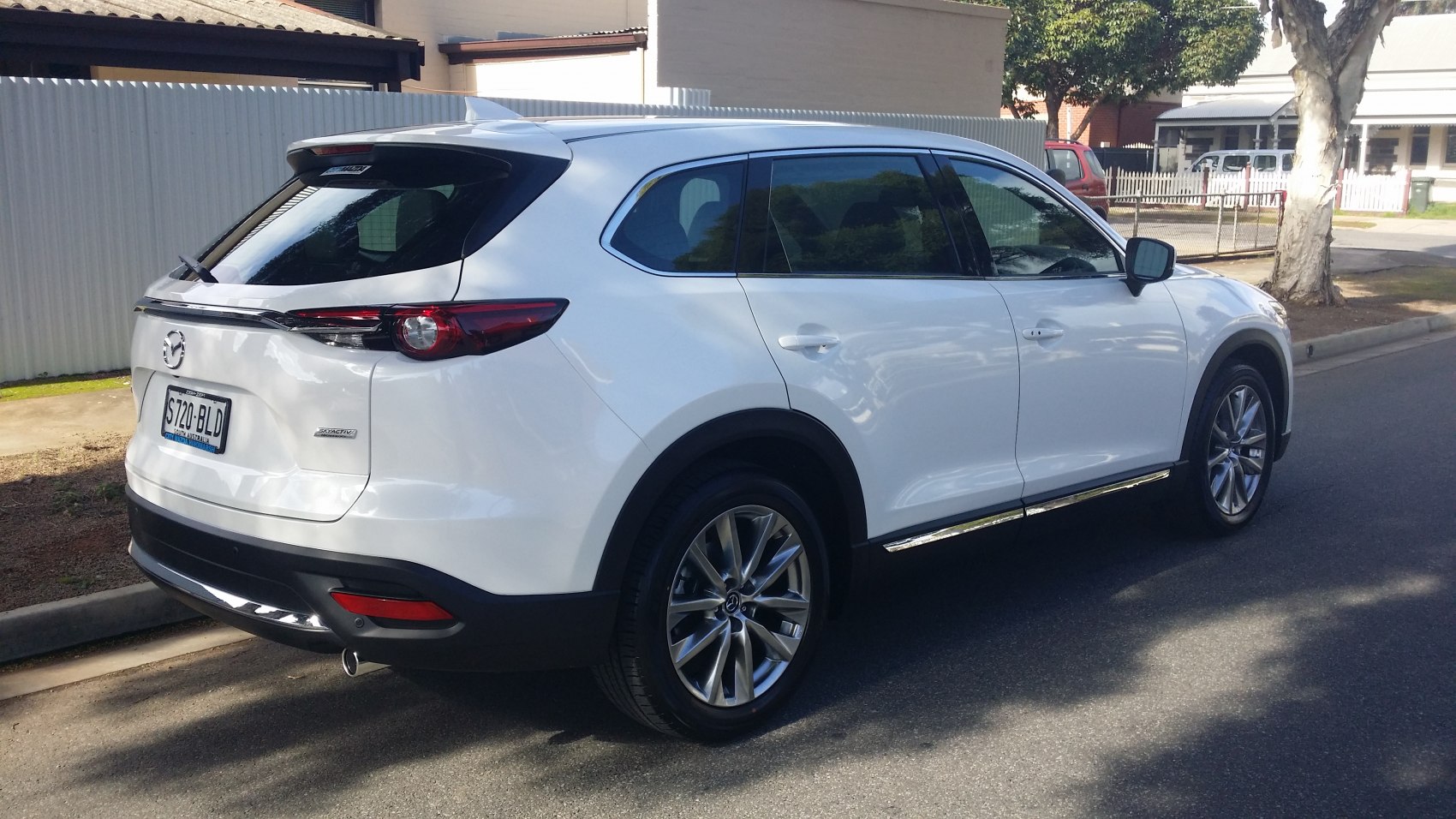 Rear side view of white SUV with sleek tail lights and alloy wheels.