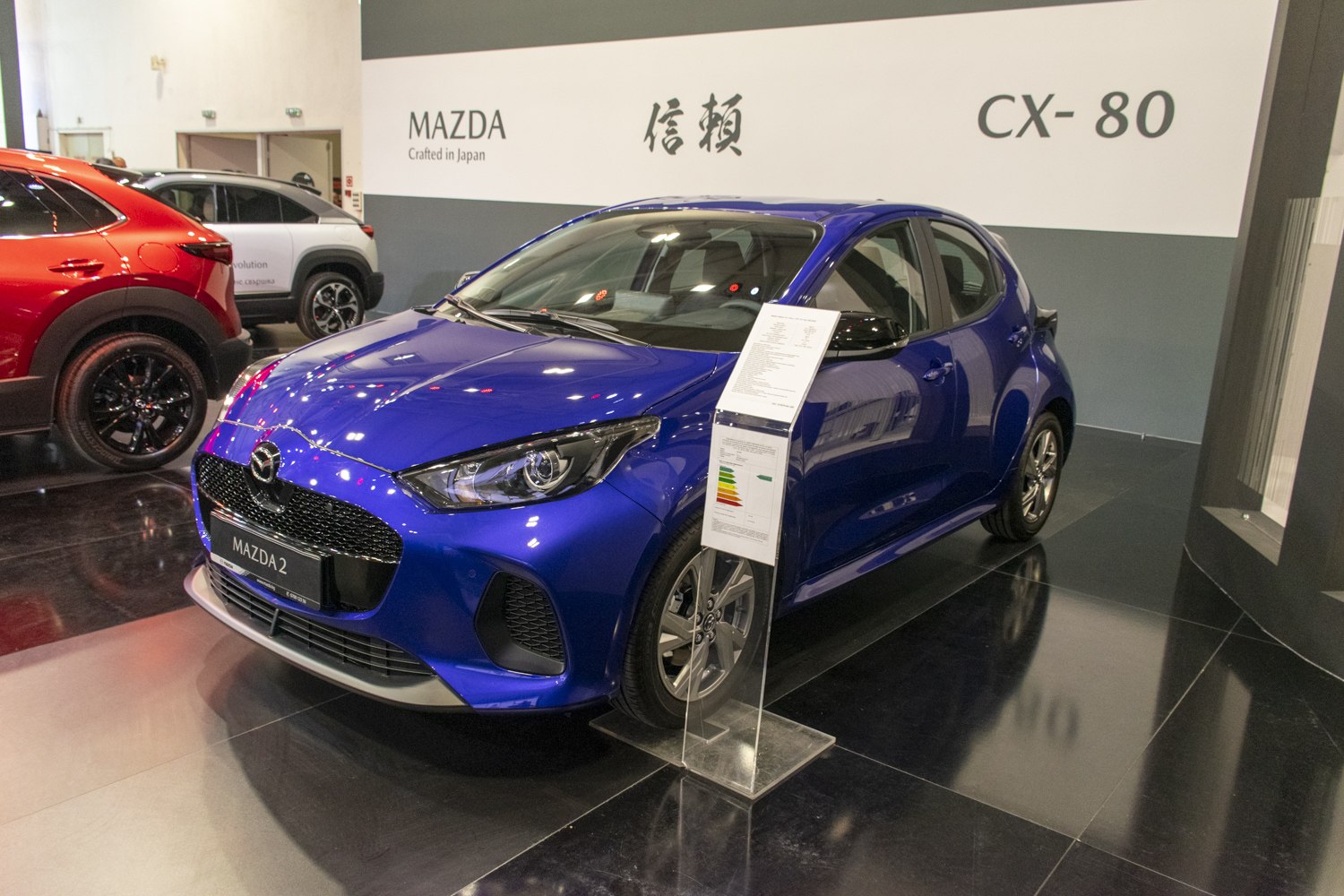 Blue compact hatchback with modern headlights and prominent front grille