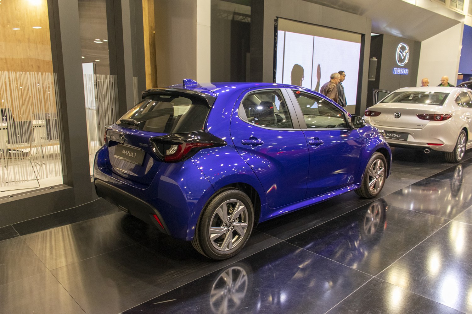 Rear and side view of blue modern hatchback with distinct taillights and wheel rims