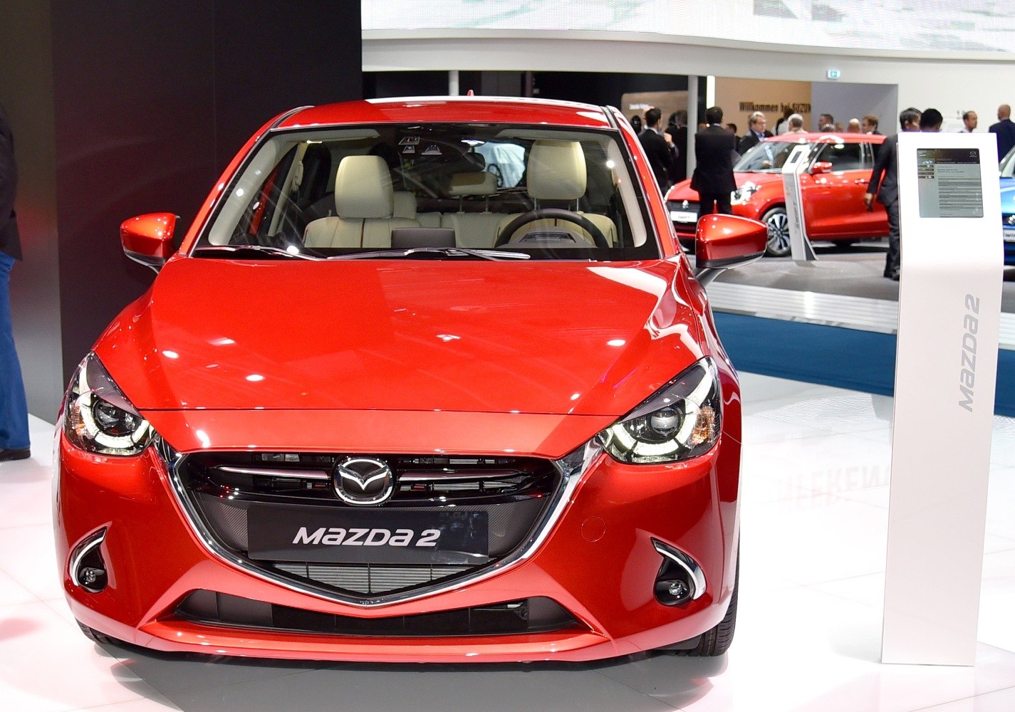 Front view of a red compact hatchback with prominent headlights and grille