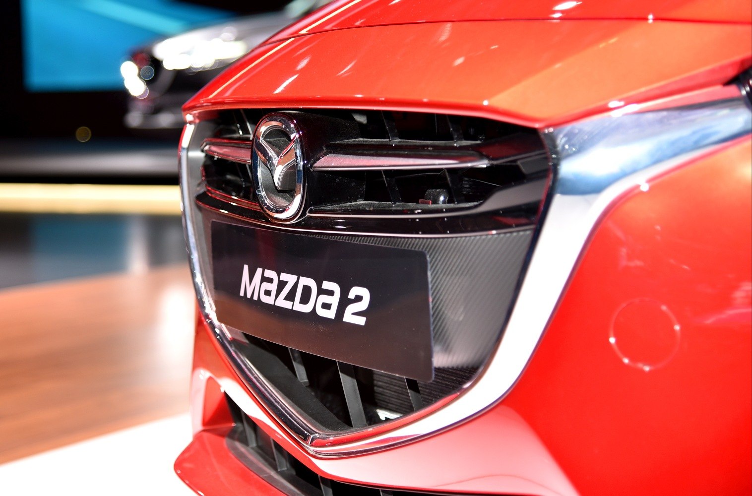 Close-up of front grille with Mazda emblem and license plate.