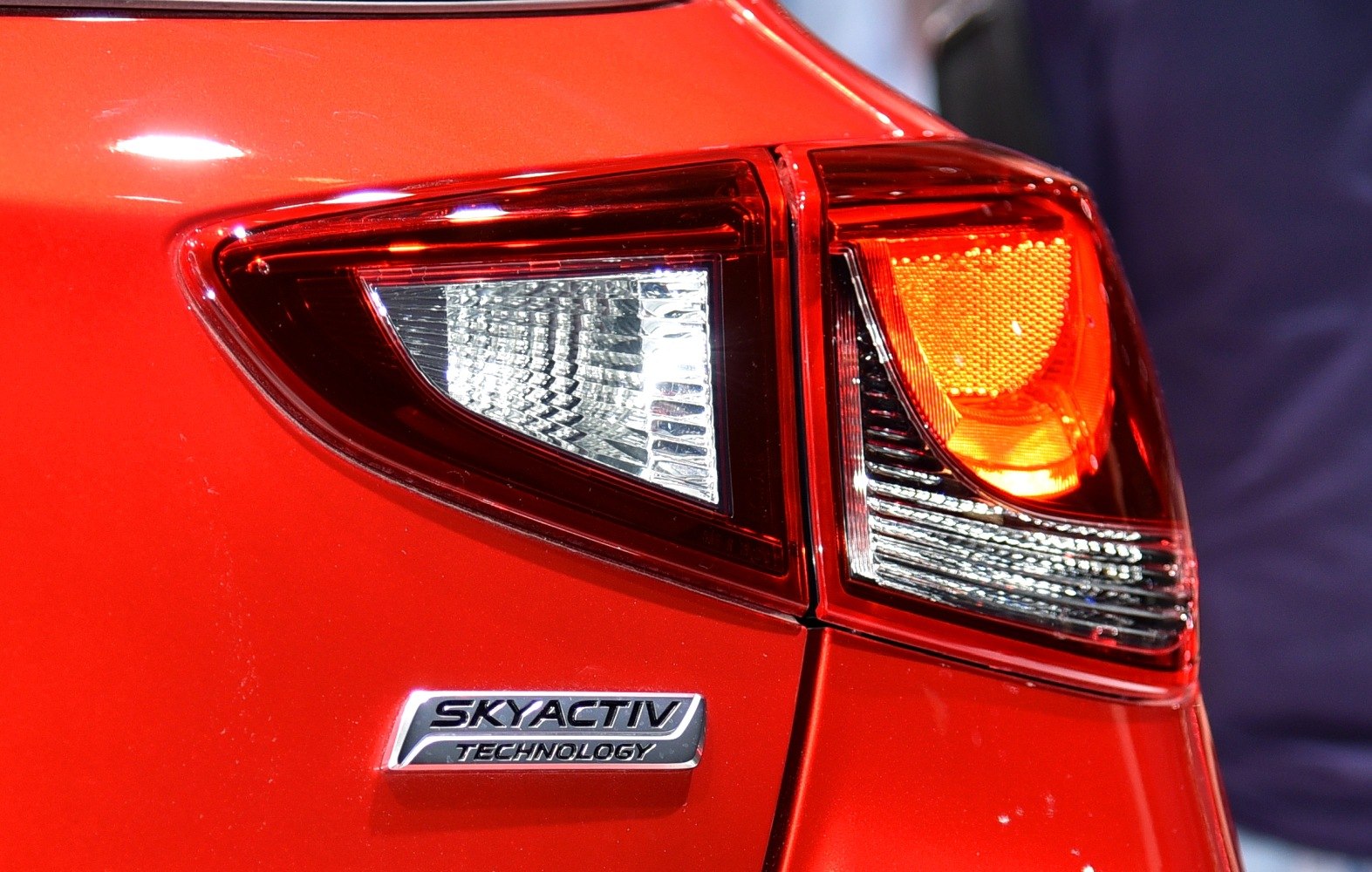 Close-up of rear tail light and SKYACTIV badge on red surface