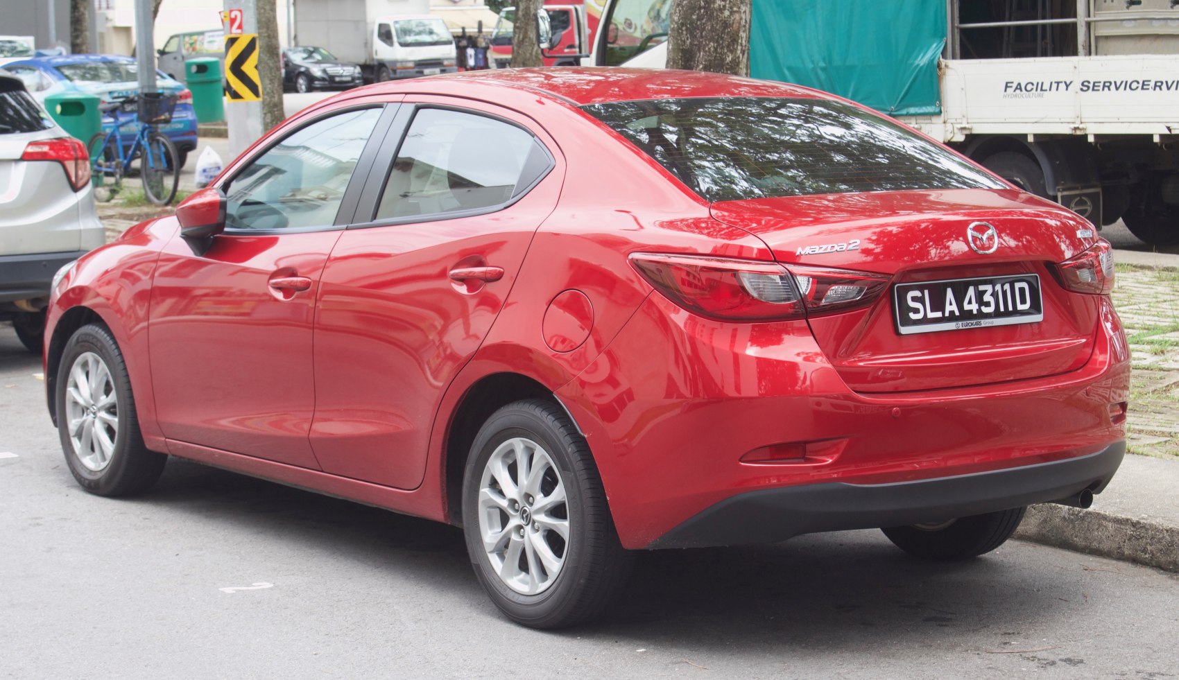 Red sedan rear view with alloy wheels and modern taillights