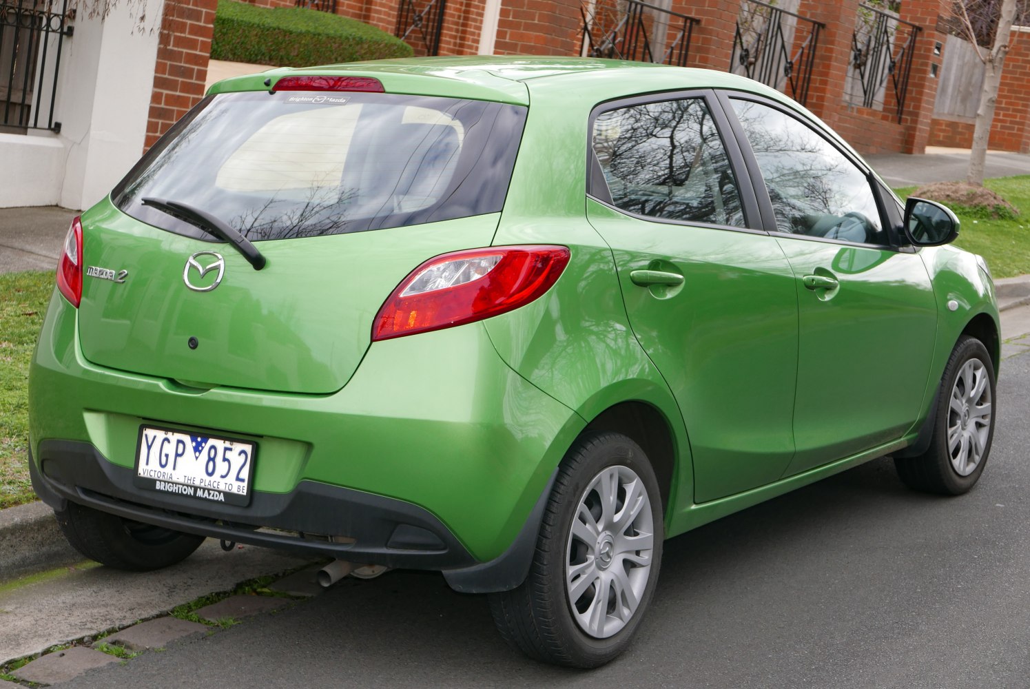 Rear and side view of green hatchback with distinctive taillights and rear wiper