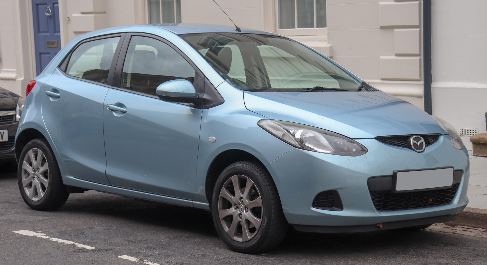 Blue compact hatchback showing front and side profile with alloy wheels.