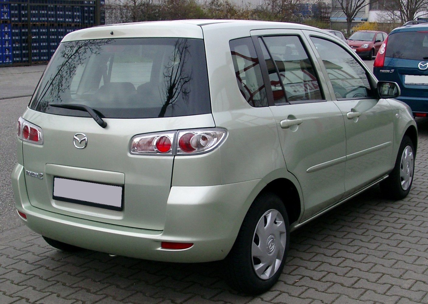 Compact hatchback rear view with rounded tail lights and rear windshield wiper
