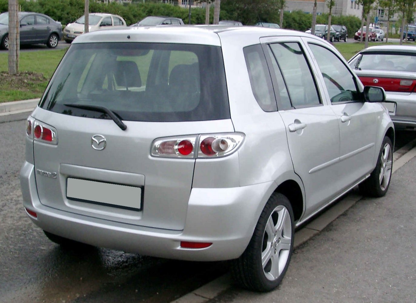 Rear-side view of a silver hatchback with clear taillights and five-door layout