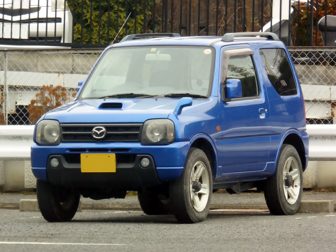 Blue compact off-road SUV with hood scoop and roof rails