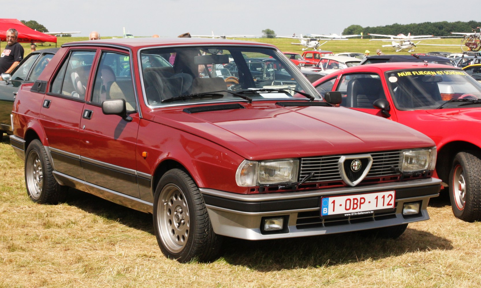 Red vintage sedan with distinctive front grille and rectangular headlights