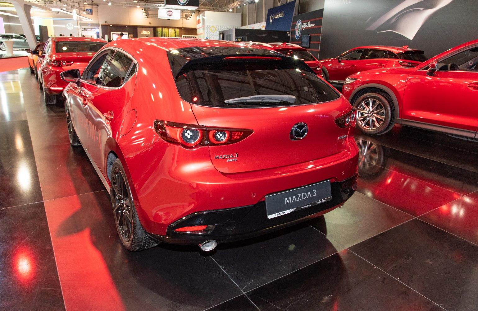 Rear view of a red hatchback with twin round tail lights and sporty rear bumper.