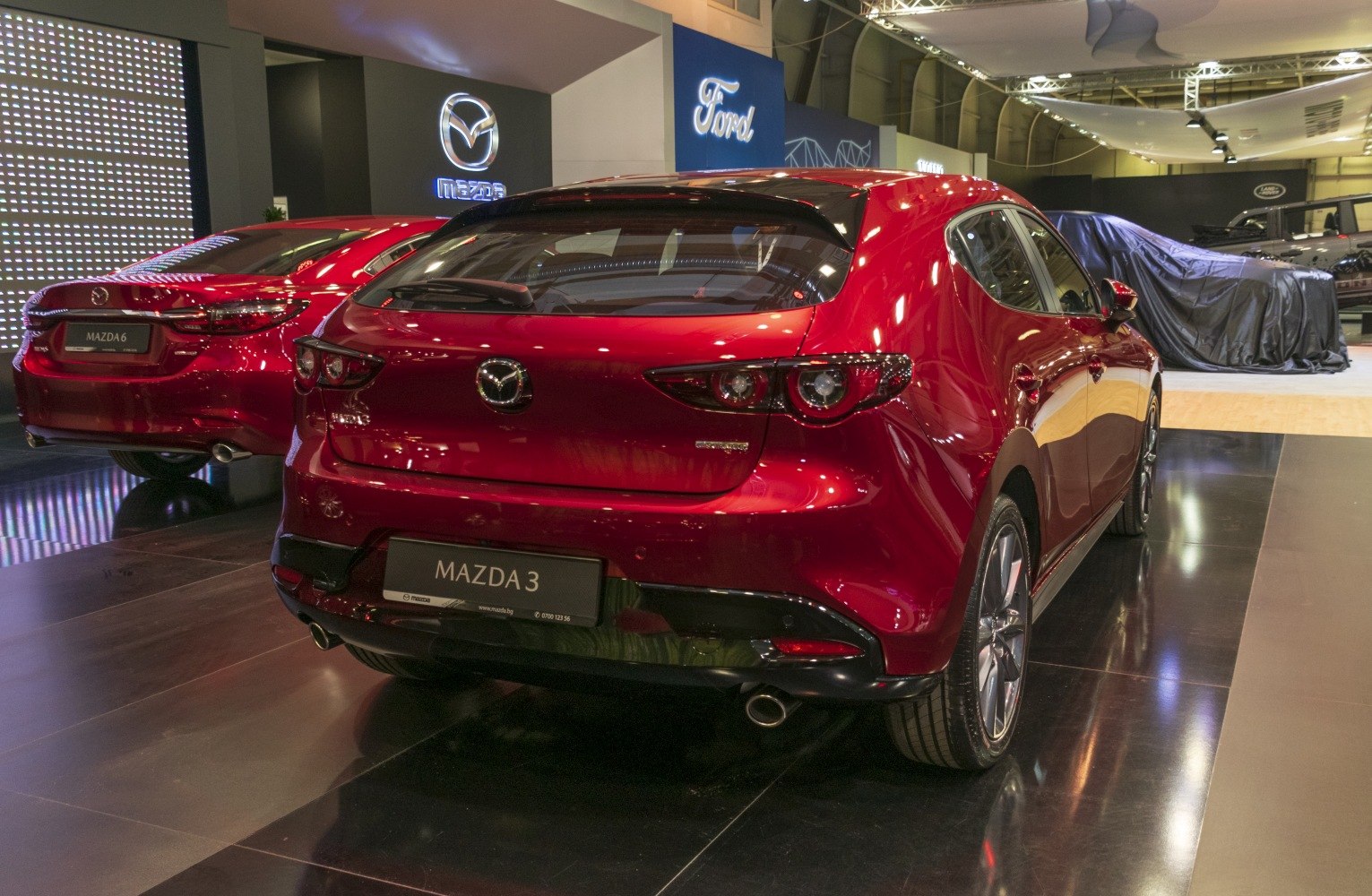 Rear view of a red hatchback with distinctive taillights and dual exhaust