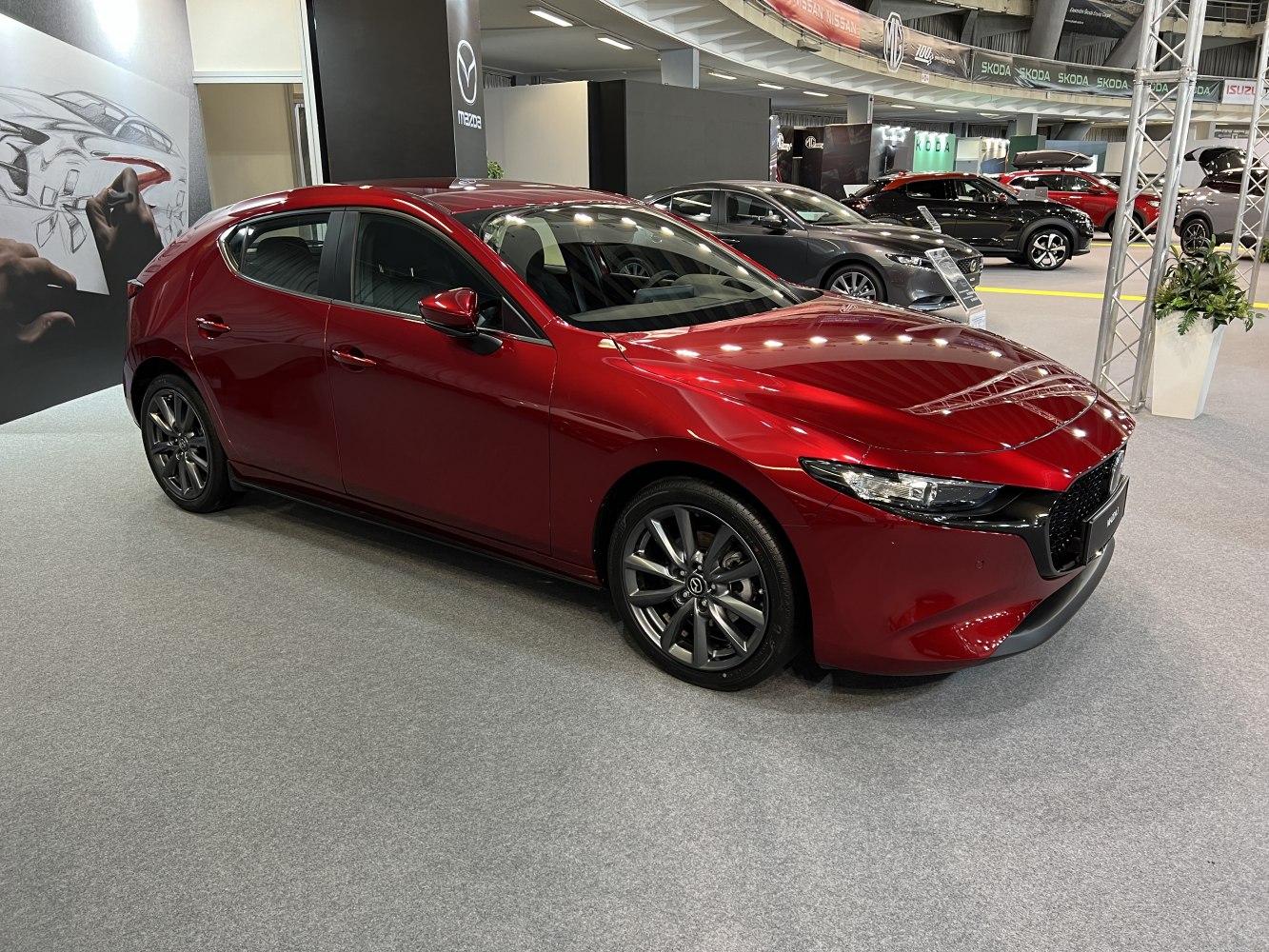 Red hatchback with sharp headlights and sporty alloy wheels