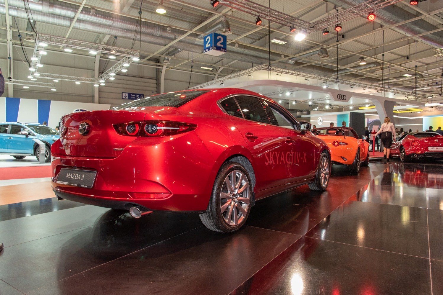 Red sedan rear with dual round tail lights and single exhaust pipe