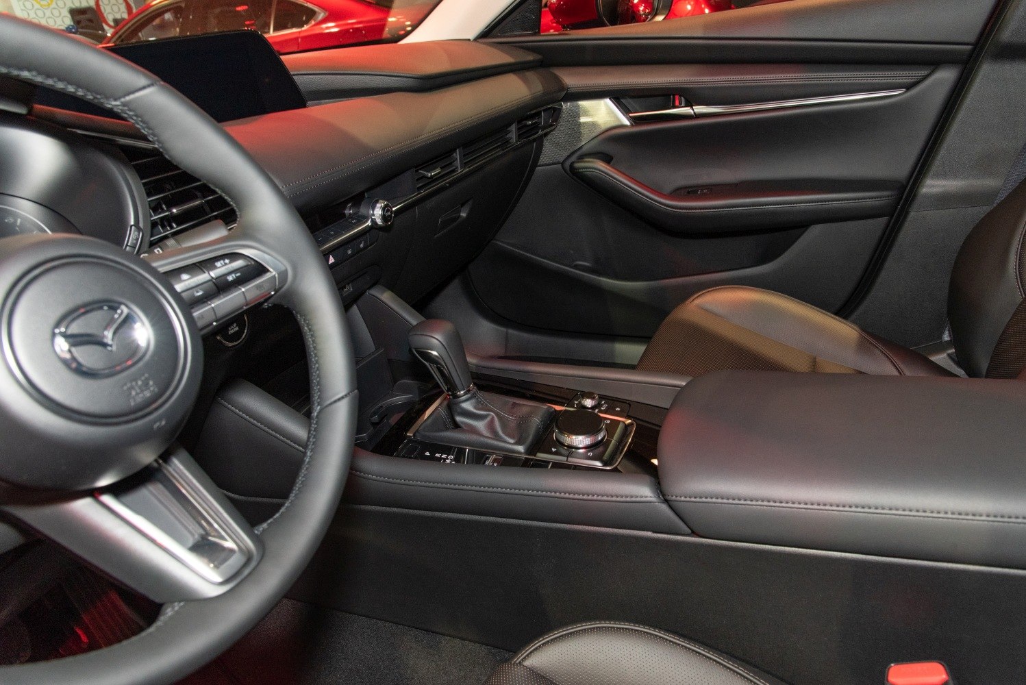 Modern car interior with infotainment system, gear shift, and leather seating