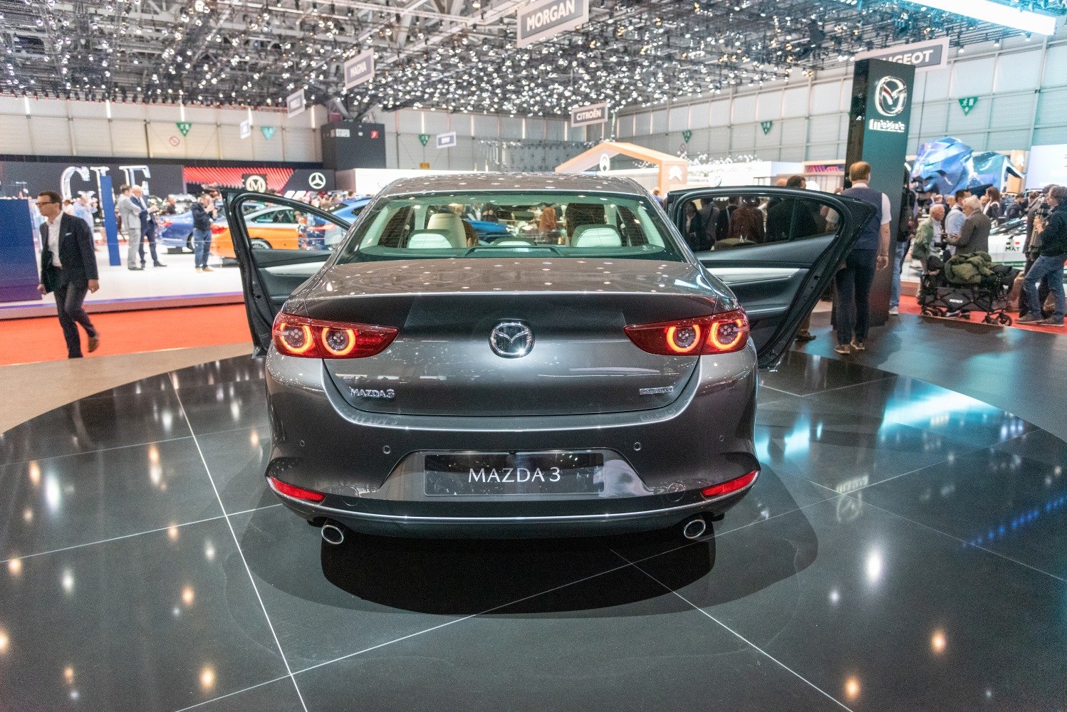 Rear view of a sedan with circular taillights and open rear doors