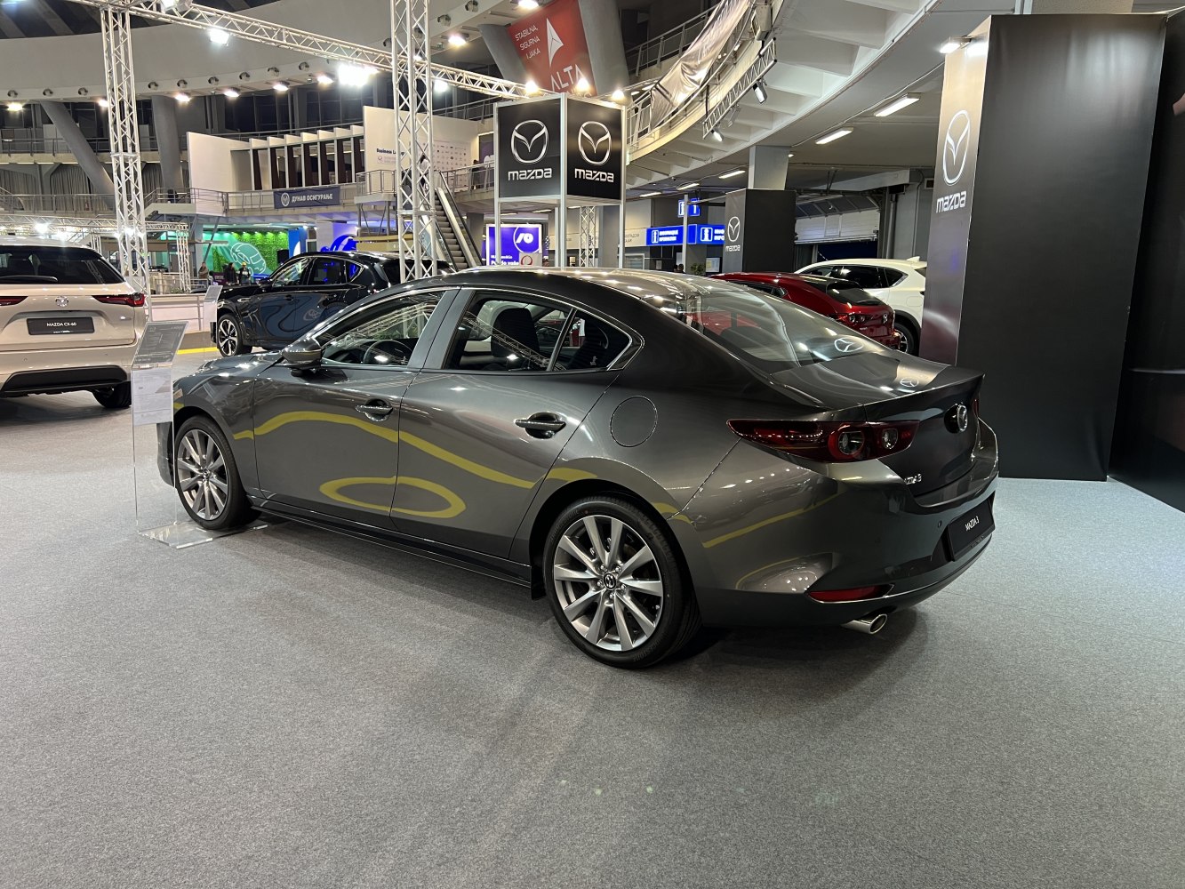 Rear and side profile of a sleek sedan with alloy wheels and distinctive tail lights