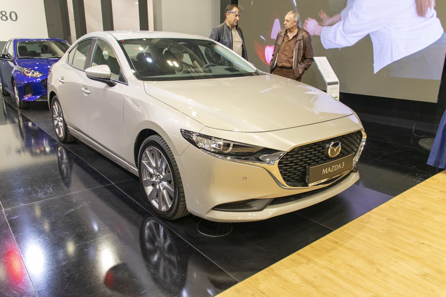Close view of a sedan's front with LED headlights and mesh grille