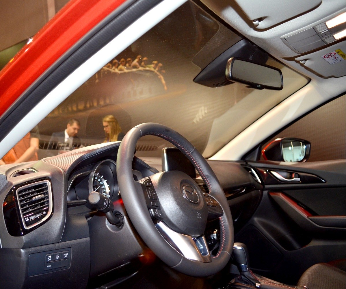 Steering wheel and dashboard interior with control buttons and display screen