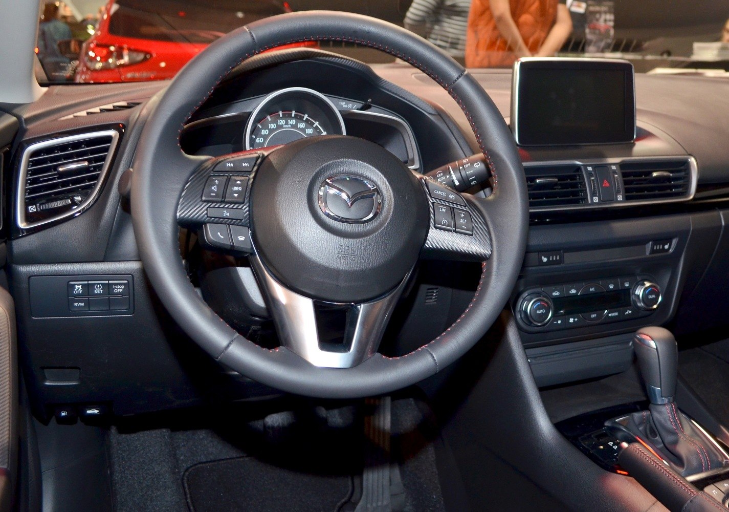 Steering wheel, dashboard, infotainment screen, and center console inside a car