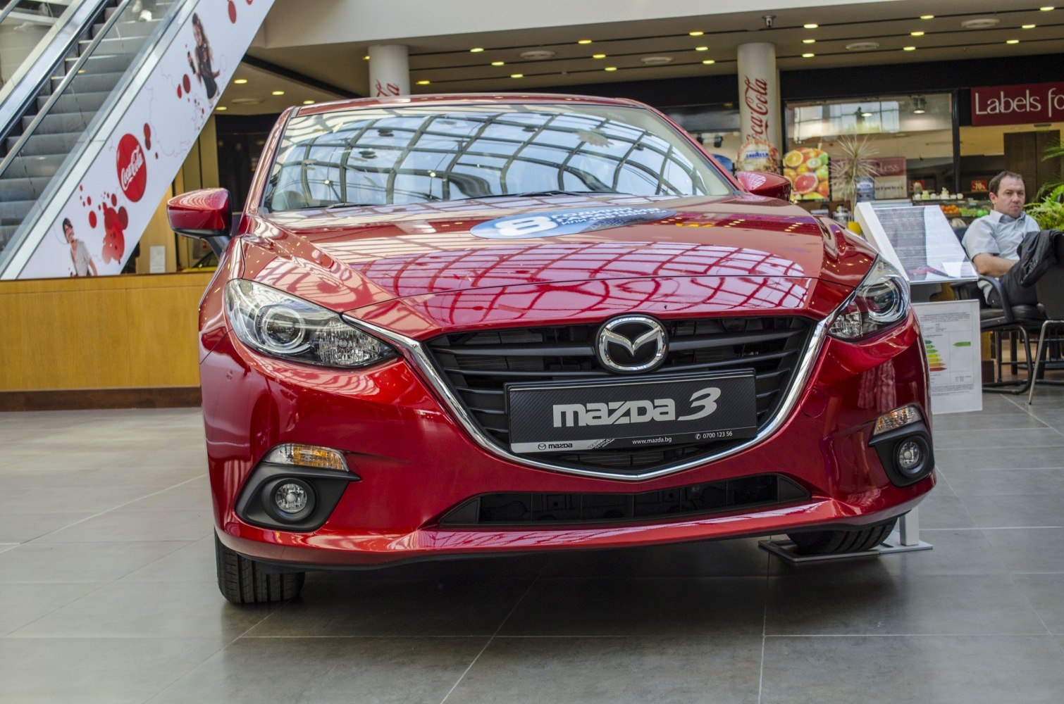 Front view with grille, headlights, and badge of a red sedan