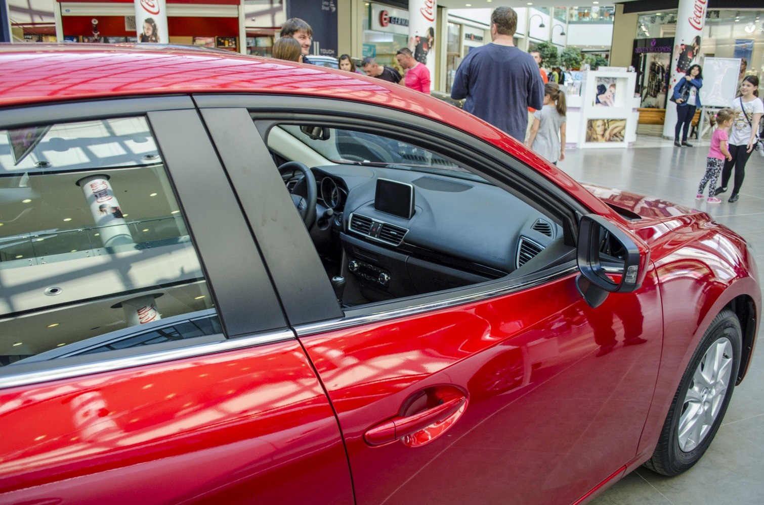 Sleek red car side with interior dashboard and touchscreen display