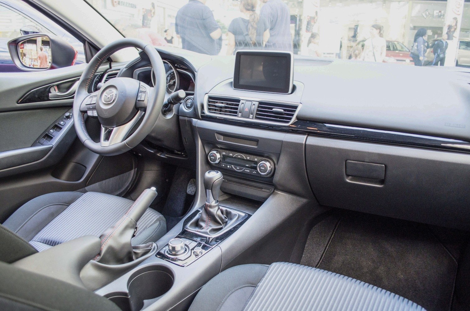 Interior dashboard with steering wheel, manual gearshift, and infotainment display
