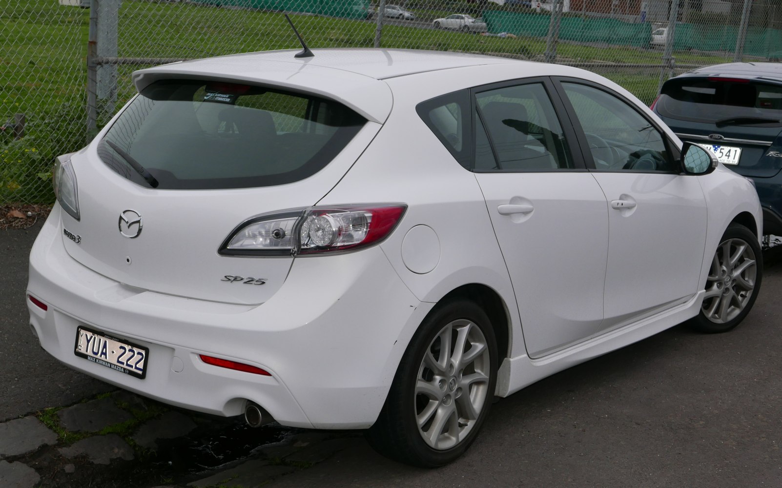 Rear and side view of white hatchback with alloy wheels and rear spoiler