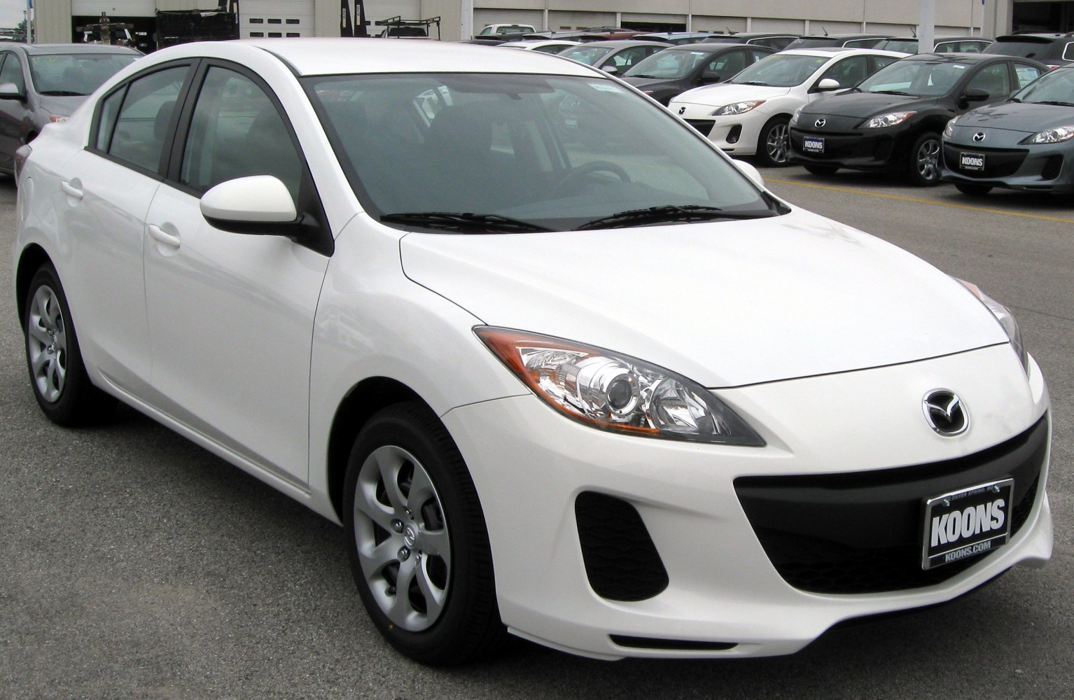 Front and side view of white sedan with distinct headlight and grille