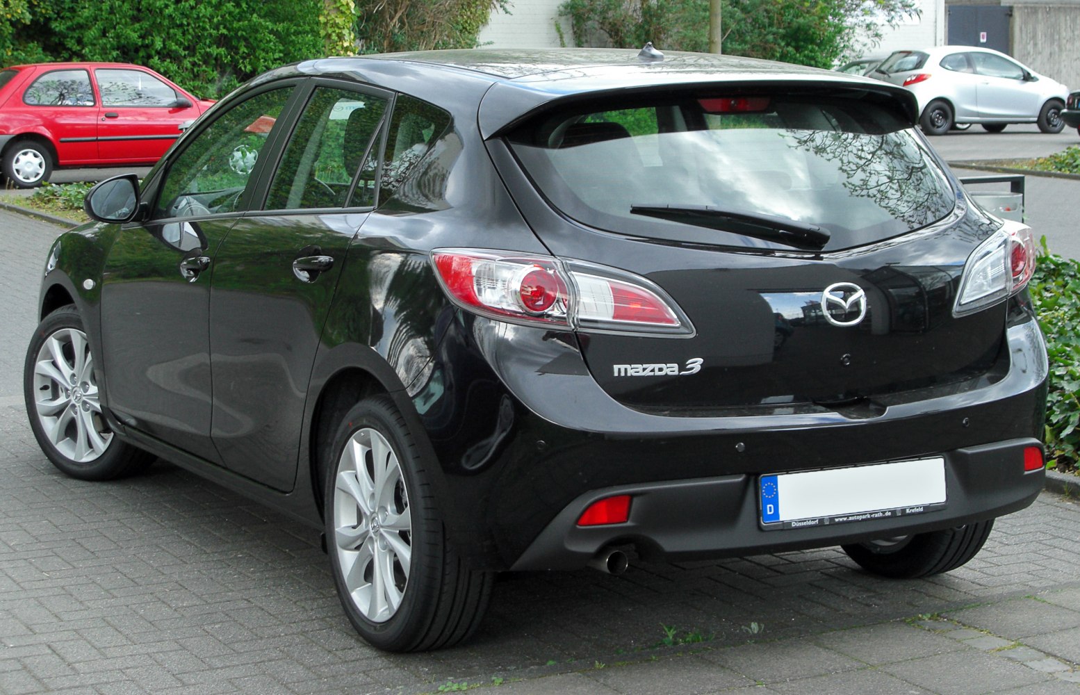 Rear view of black hatchback with clear taillights and rear wiper