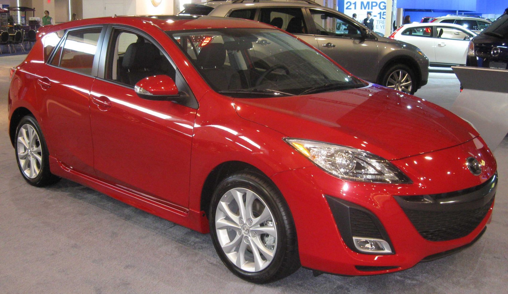 Red hatchback with sharp headlights and alloy wheels