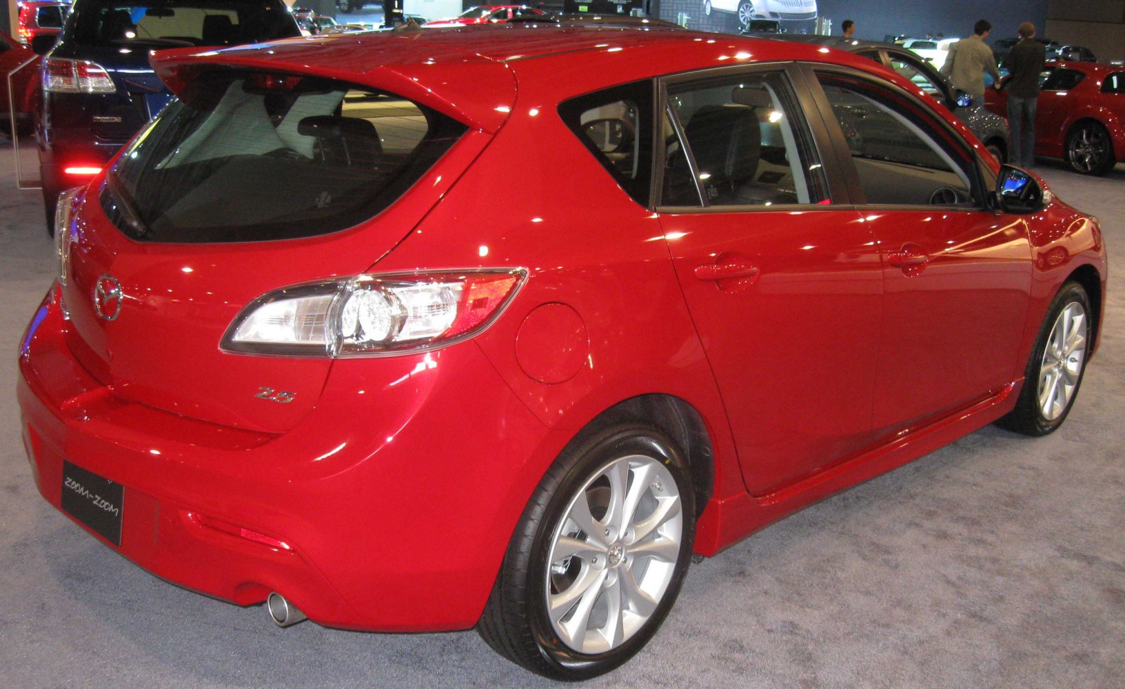 Red compact hatchback rear side view with alloy wheels and taillights