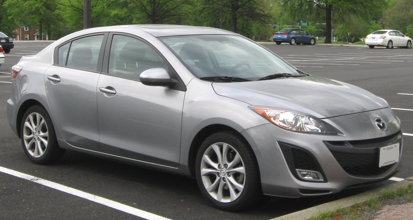 Gray 4-door sedan with alloy wheels and aerodynamic front in parking lot