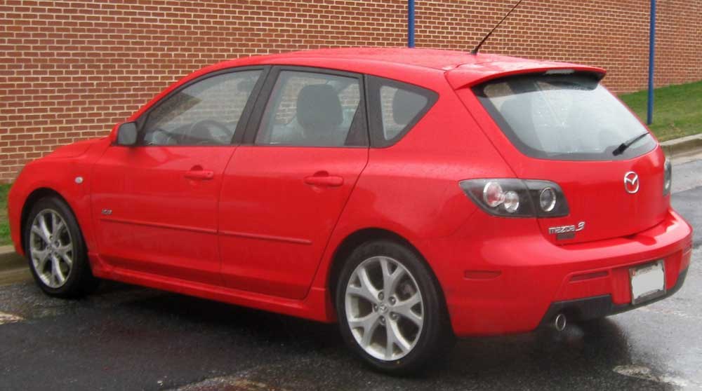 Rear side profile of red hatchback with alloy wheels and unique taillights