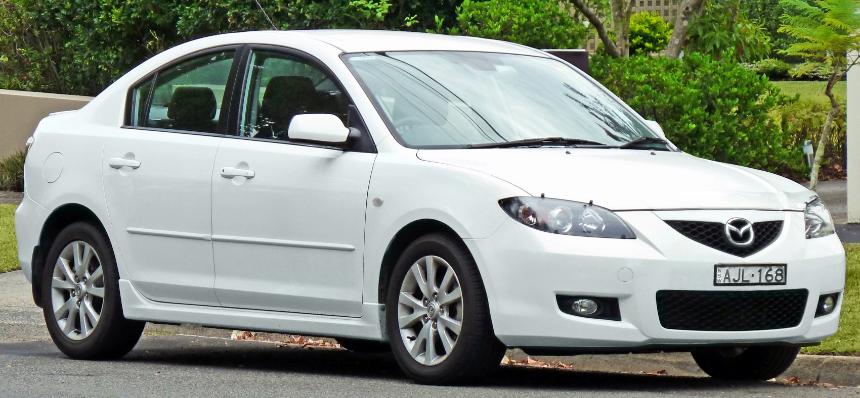 Front side view of a compact sedan with alloy wheels and streamlined body.