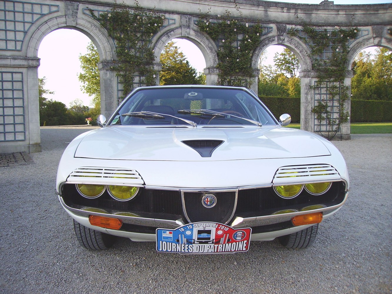 Classic car front with yellow headlights and vented hood