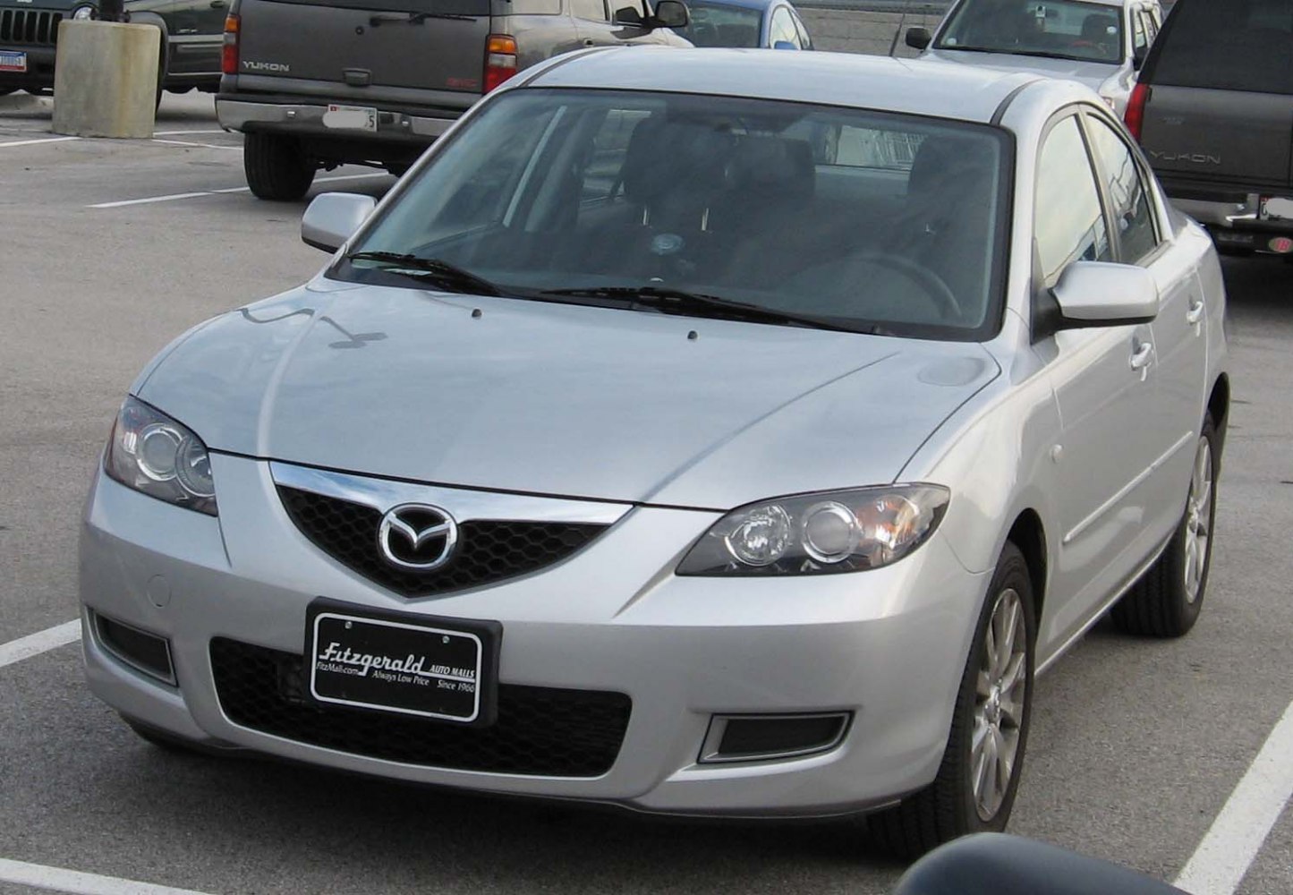 Silver compact sedan front view with distinctive headlights and grille.