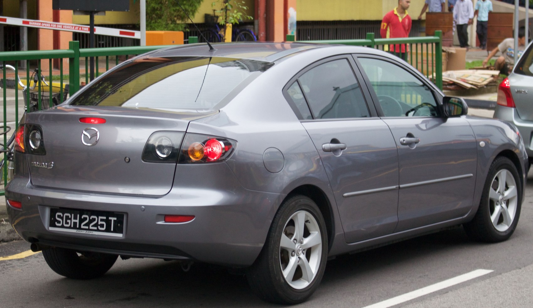 Rear side view of sedan with round taillights and alloy wheels