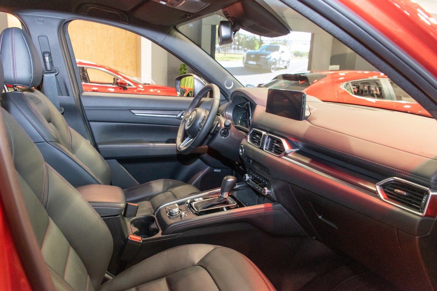 Modern black leather front seats with advanced dashboard and infotainment display