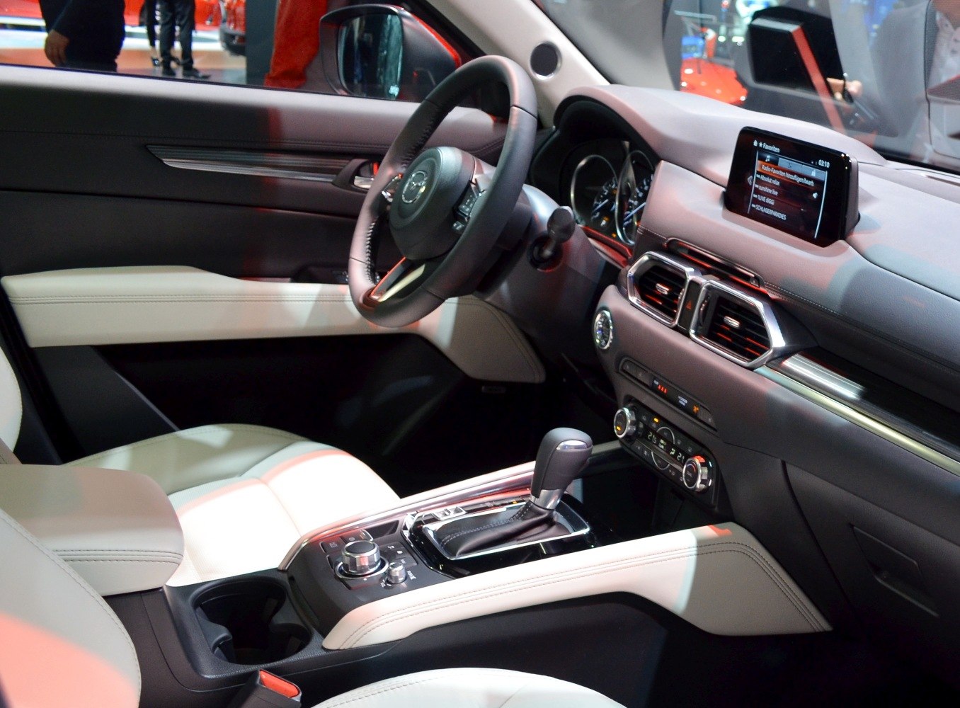Modern car interior with touchscreen, leather seats, and gear shift.