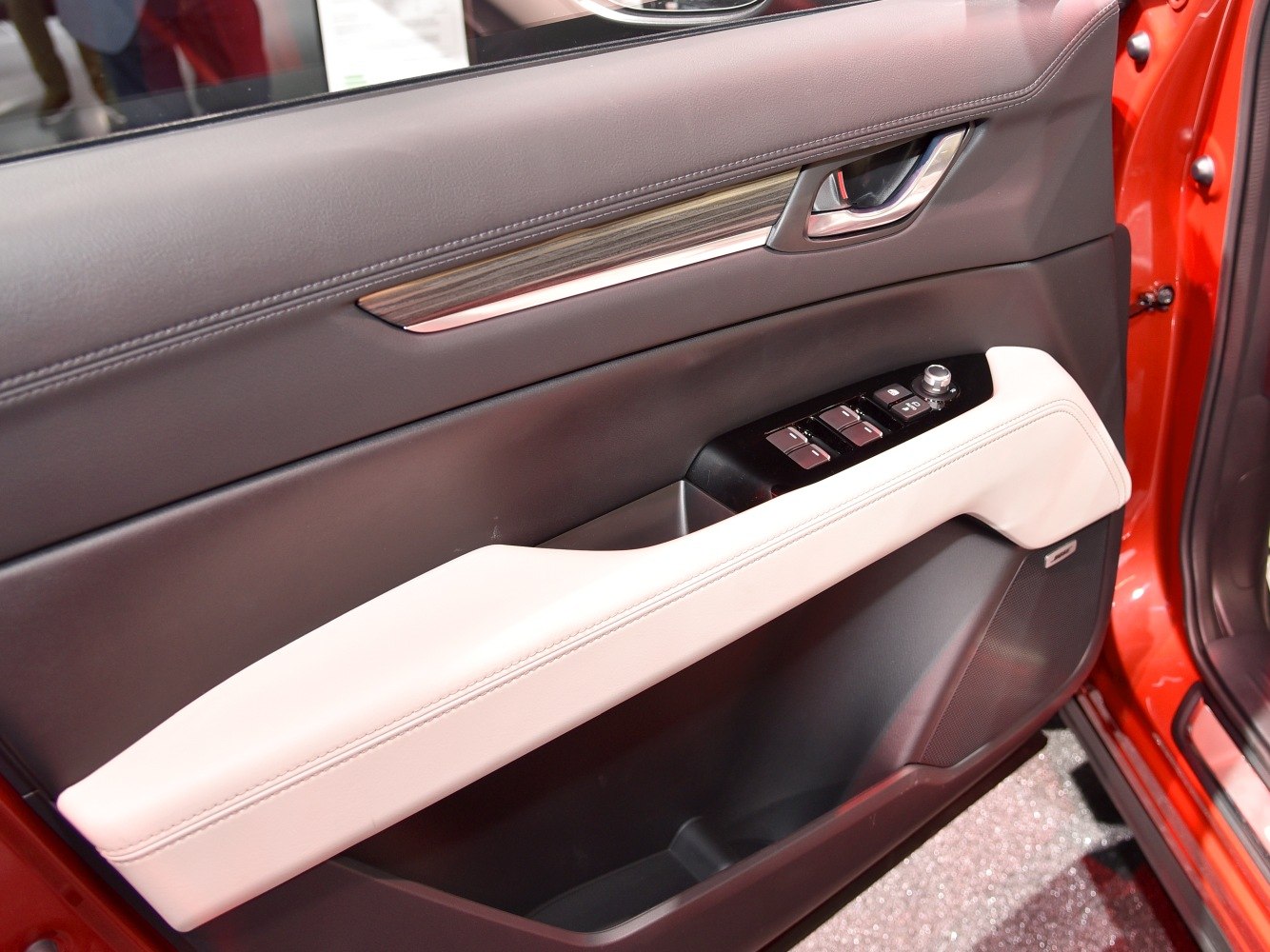 Car door panel with window controls and leather armrest