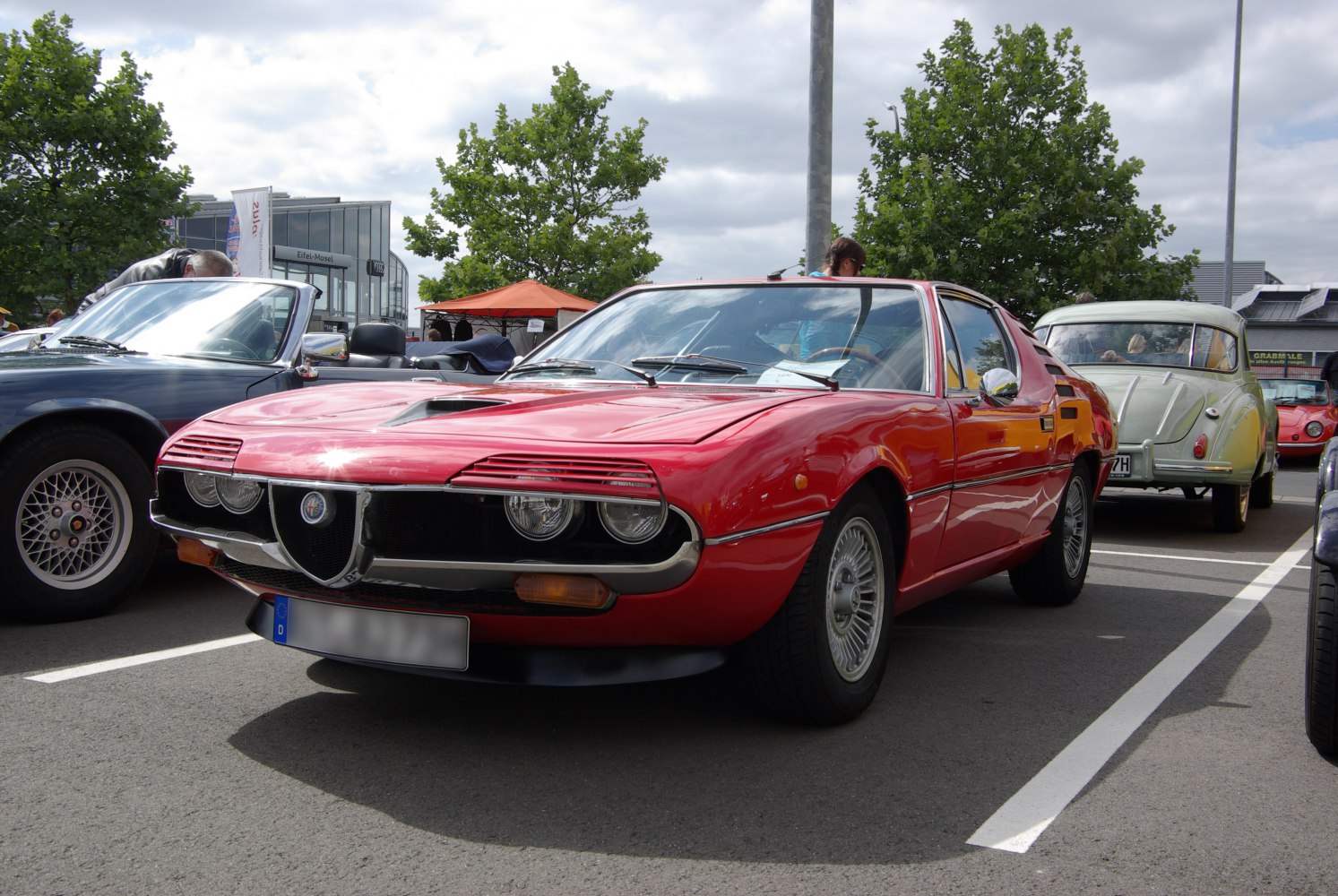 Retro red coupe with covered headlights and sporty front design