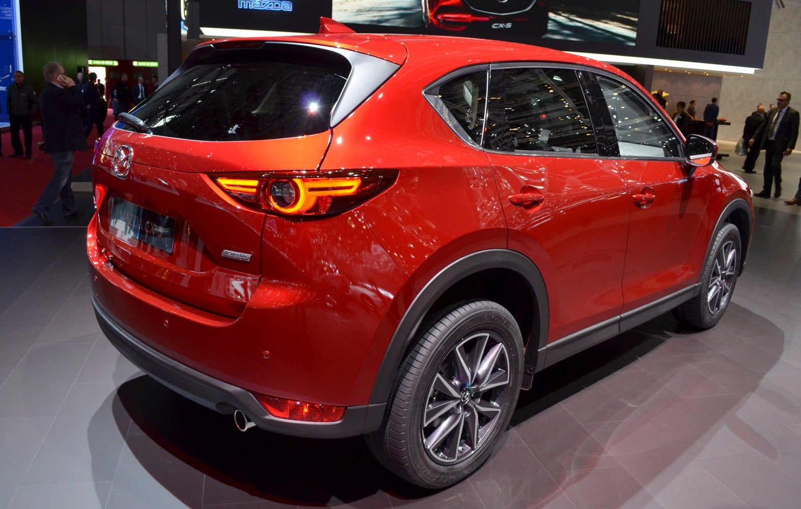 Rear design and tail light of a modern red SUV with detailed rear wheel.
