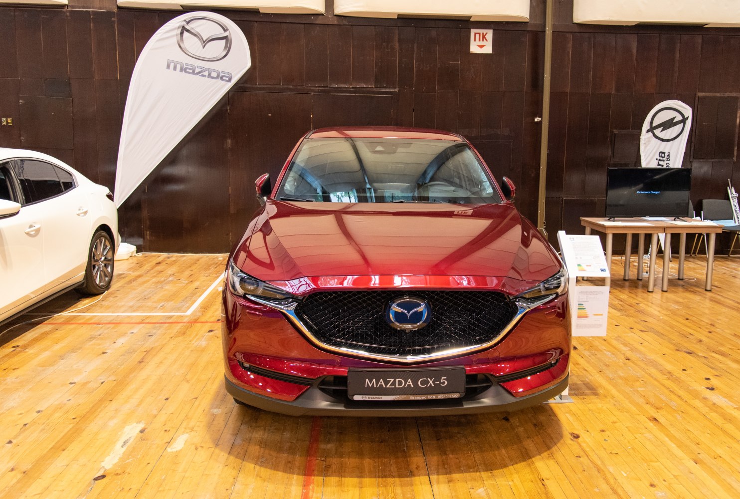 Sleek SUV front with signature grille and sharp headlights in red paint