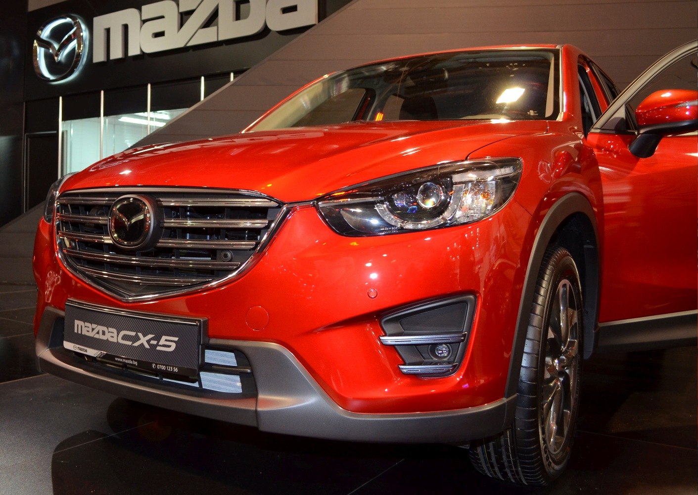 Front grille and headlight close-up of red Mazda SUV