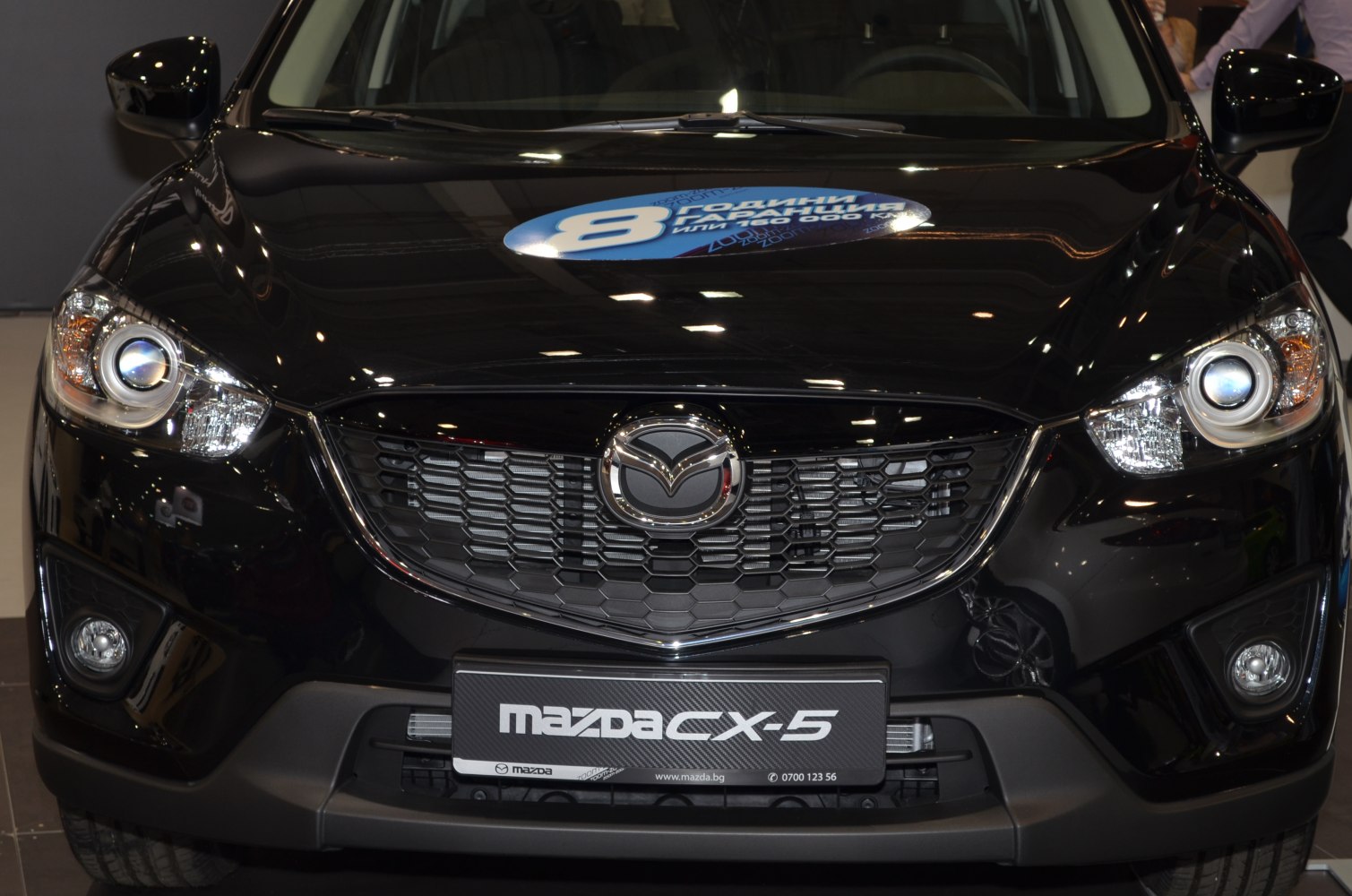 Close-up of front grille and headlights with Mazda emblem