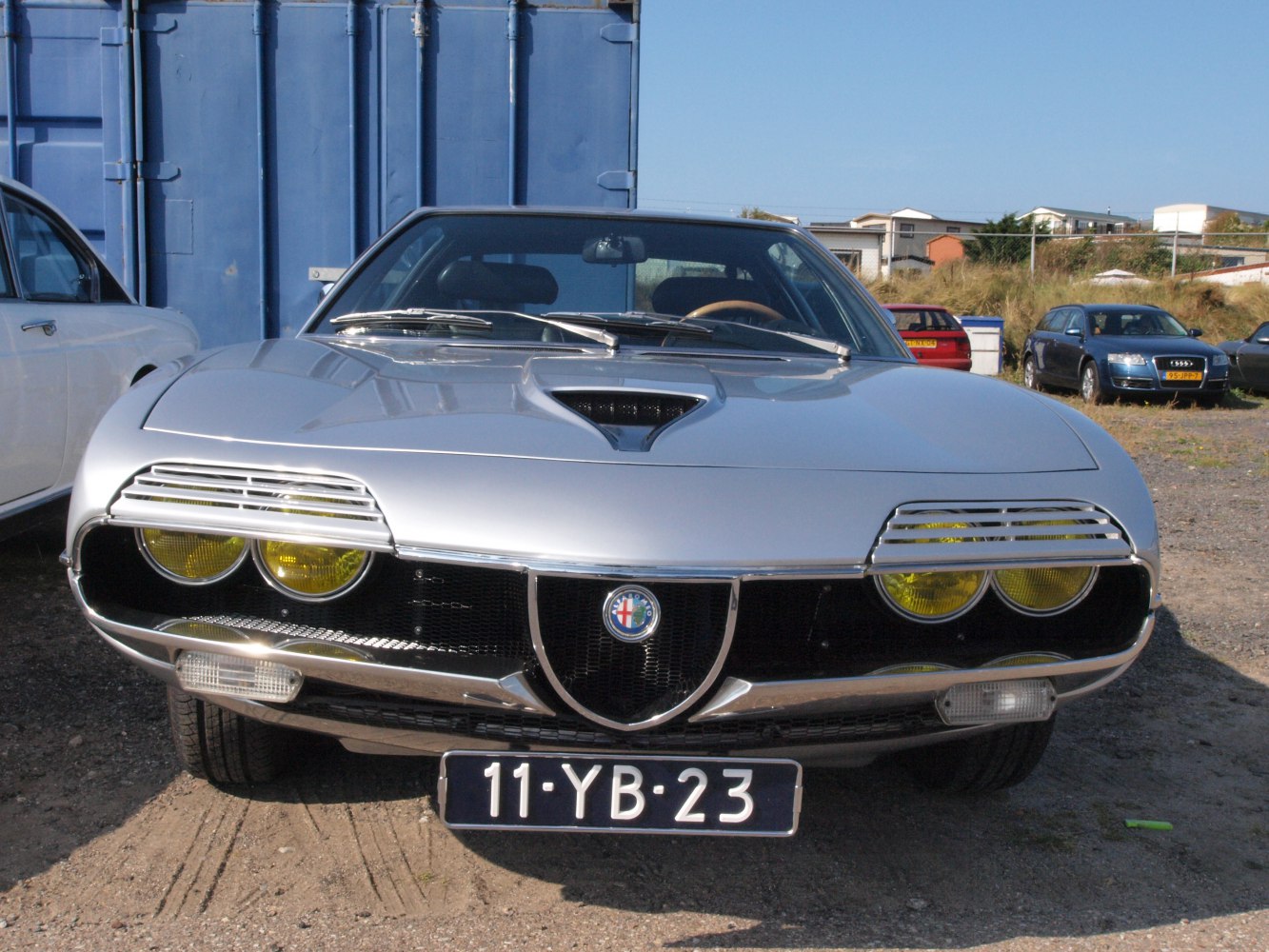 Classic car front with yellow headlights and vented hood scoop