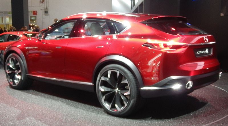 Side and rear view of a red SUV with large wheels and sleek design