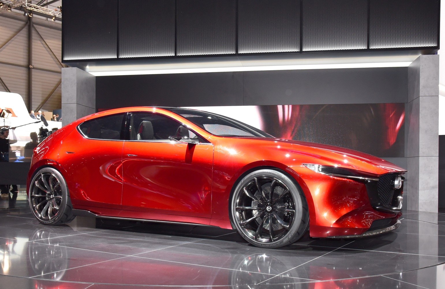 Sleek red hatchback with large alloy wheels and aggressive front grille