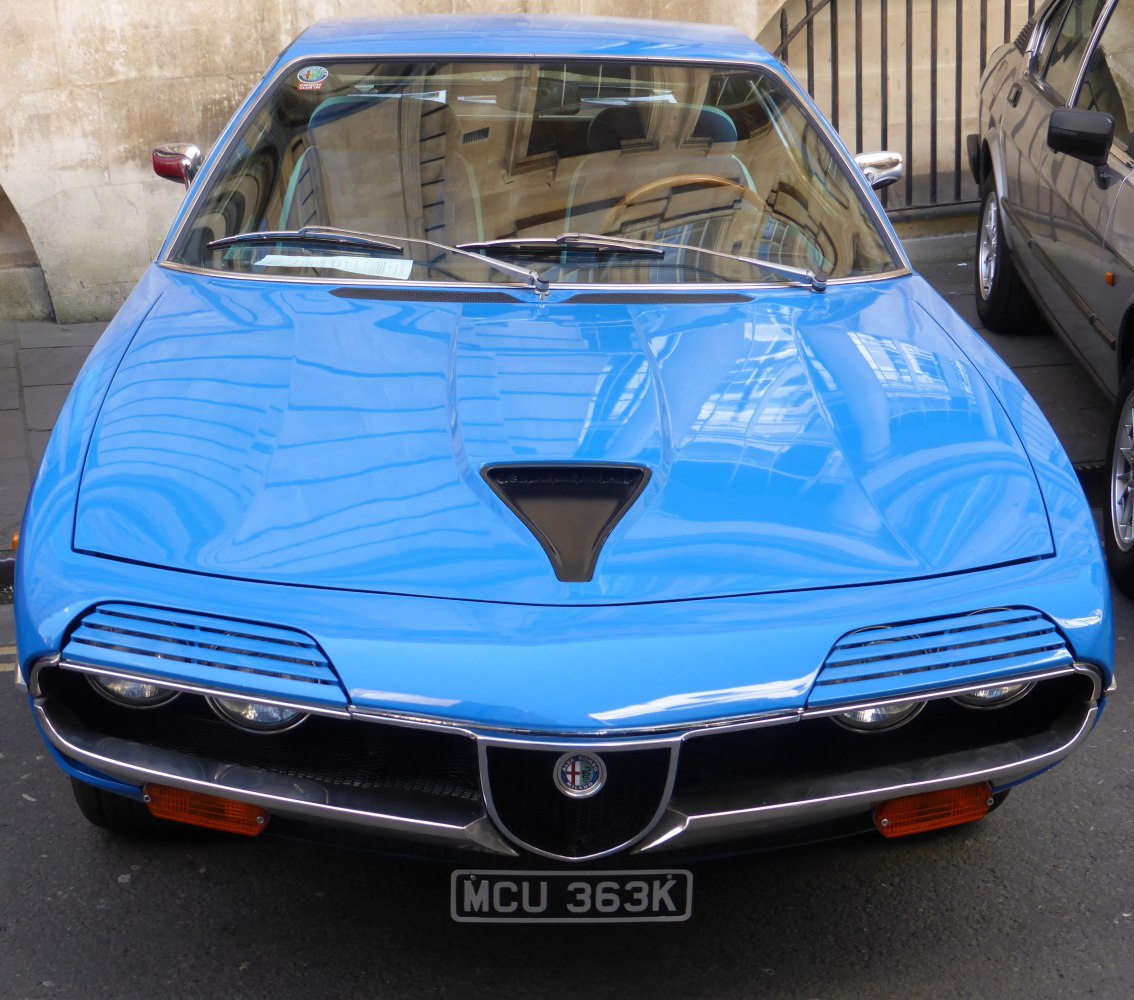 Blue classic sports car front with pop-up headlights and aerodynamic design