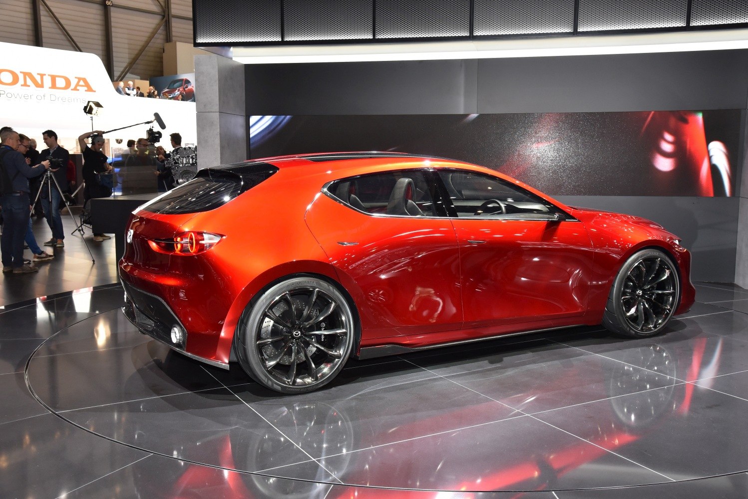 Sporty red hatchback with circular rear lights and black multi-spoke rims